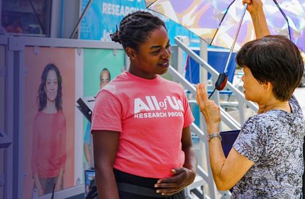 An All of Us employees speaks with a woman