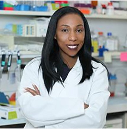 Dr. Tanner in lab coat in lab, arms folded