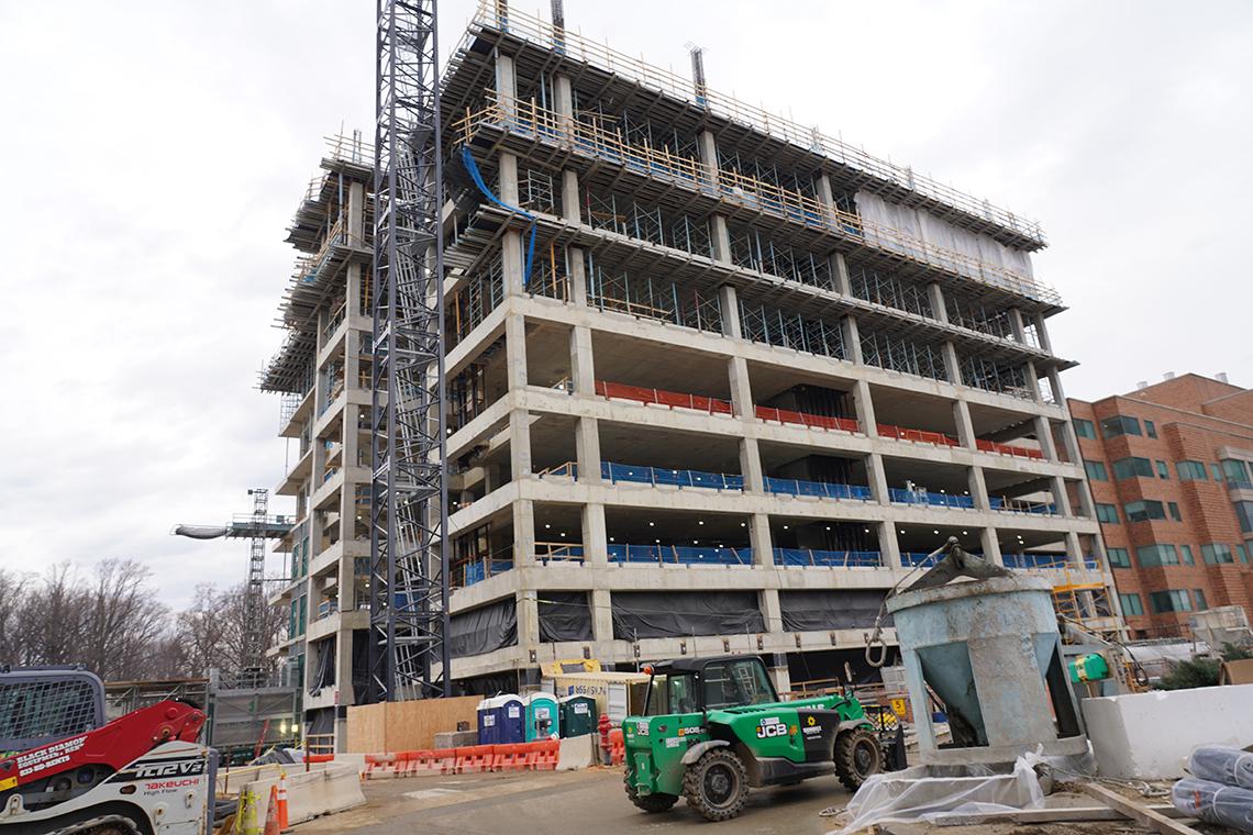 The exterior of a multi-level construction project, surrounded by scaffolds and other equipment.