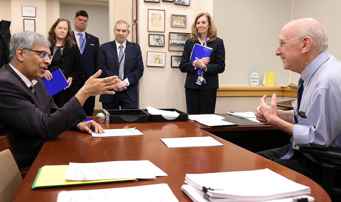Dr. Rosenberg in his office in the Clinical Center talking with Bhattacharya