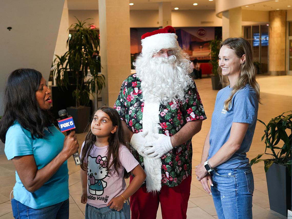 Santa and an Inn staffer are interviewed by a TV reporter