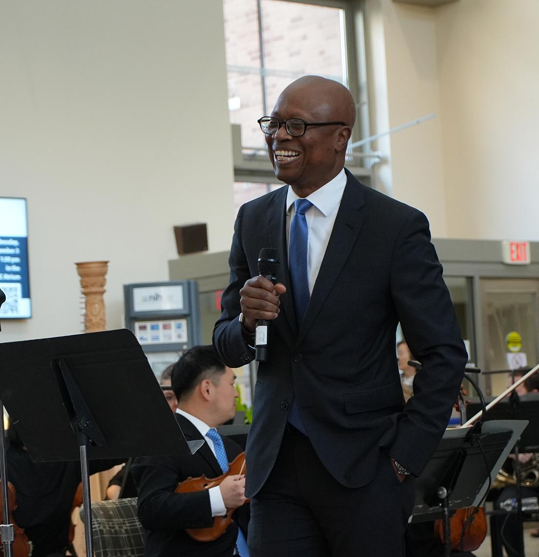 A smiling Pius Aiyelawo at the microphone