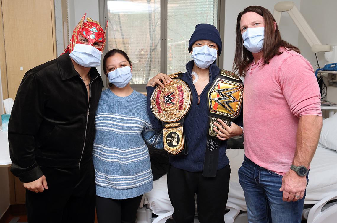 Wrestlers with patient and his mother in his hospital room