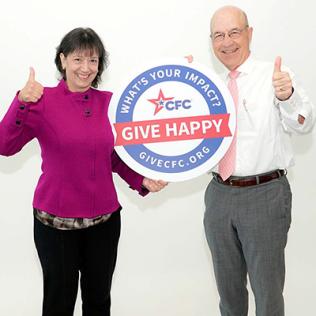 Bertagnolli and Gilman hold Give Happy CFC sign.