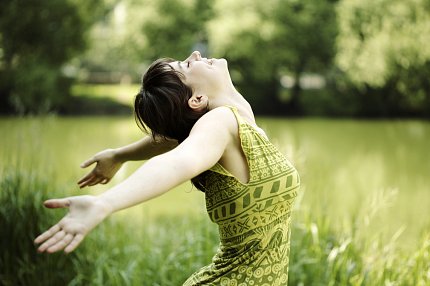 Woman in field Woman in field stretches arms wide and tilts head back.