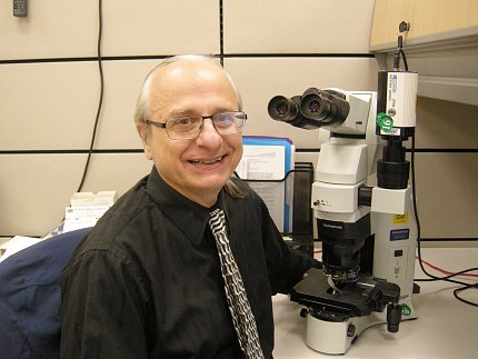 NCI’s Keith Brosky Brosky sit next a microscope
