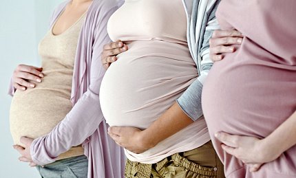 Preterm birth risk Three women place hands on their pregnant bellies.