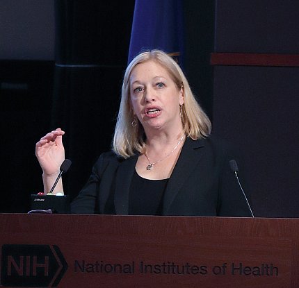 Dr. Julie Schneider Dr. Schneider presents at a podium