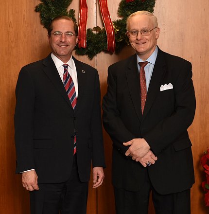 Paul Coppola and Alex Azar Coppola and Azar stand in front of a wreath