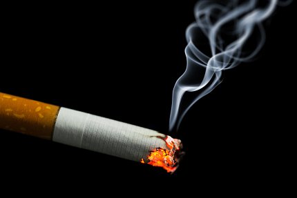 Cigarette A burning cigarette on a black background