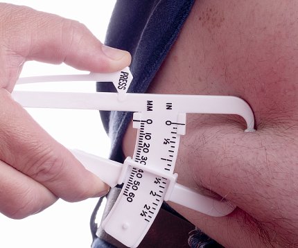 Pinching body fat A caliper pinches a person's belly fat.