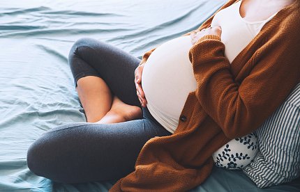 A pregnant woman holds her stomach A pregnant woman holds her stomach