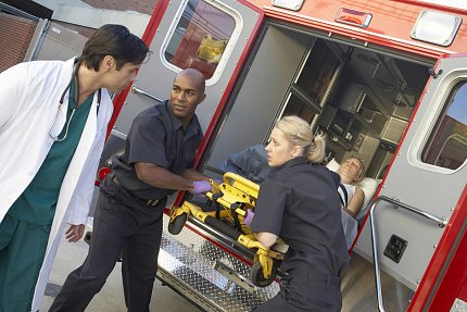 EMTs, a doctor and patient Two EMTs and one ER doctor take a patient out of an ambulance