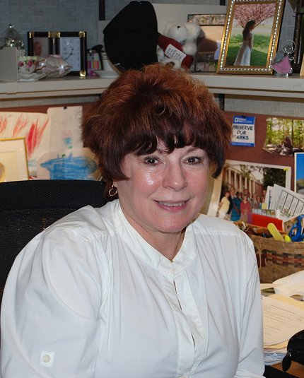 Colleen Crone Crone sits at her office desk, surrounded by family photos.