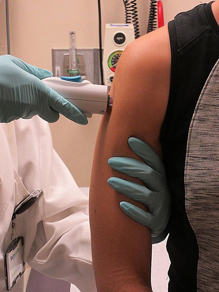 Arm being administered an injection Arm being administered an injection