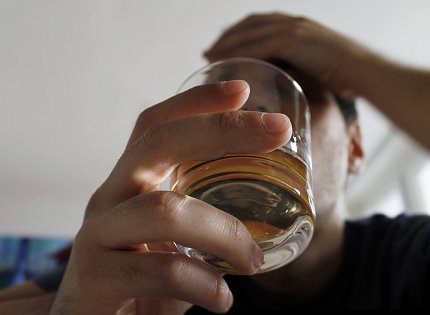 Cocktail held by man Close up of cocktail held by man with other hand holding his forehead